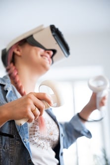 Person mit VR Brille und Controllern